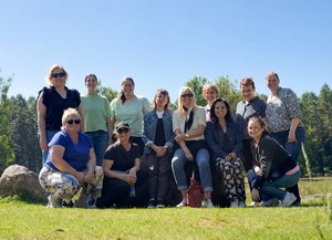 Gruppenfoto der Mitarbeitenden der Diakonie im Oldenburger Münsterland während ihres Teamausflugs in Dötlingen. Die Gruppe posiert bei sonnigem Wetter auf einer Wiese vor einer natürlichen Kulisse mit Bäumen im Hintergrund.