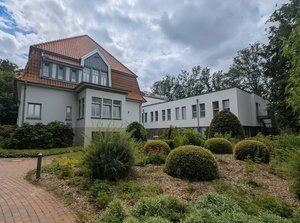 Außenansicht der Fachklinik Oldenburger Land am Standort Neerstedt mit Klinikgebäuden und bepflanzter Gartenanlage.