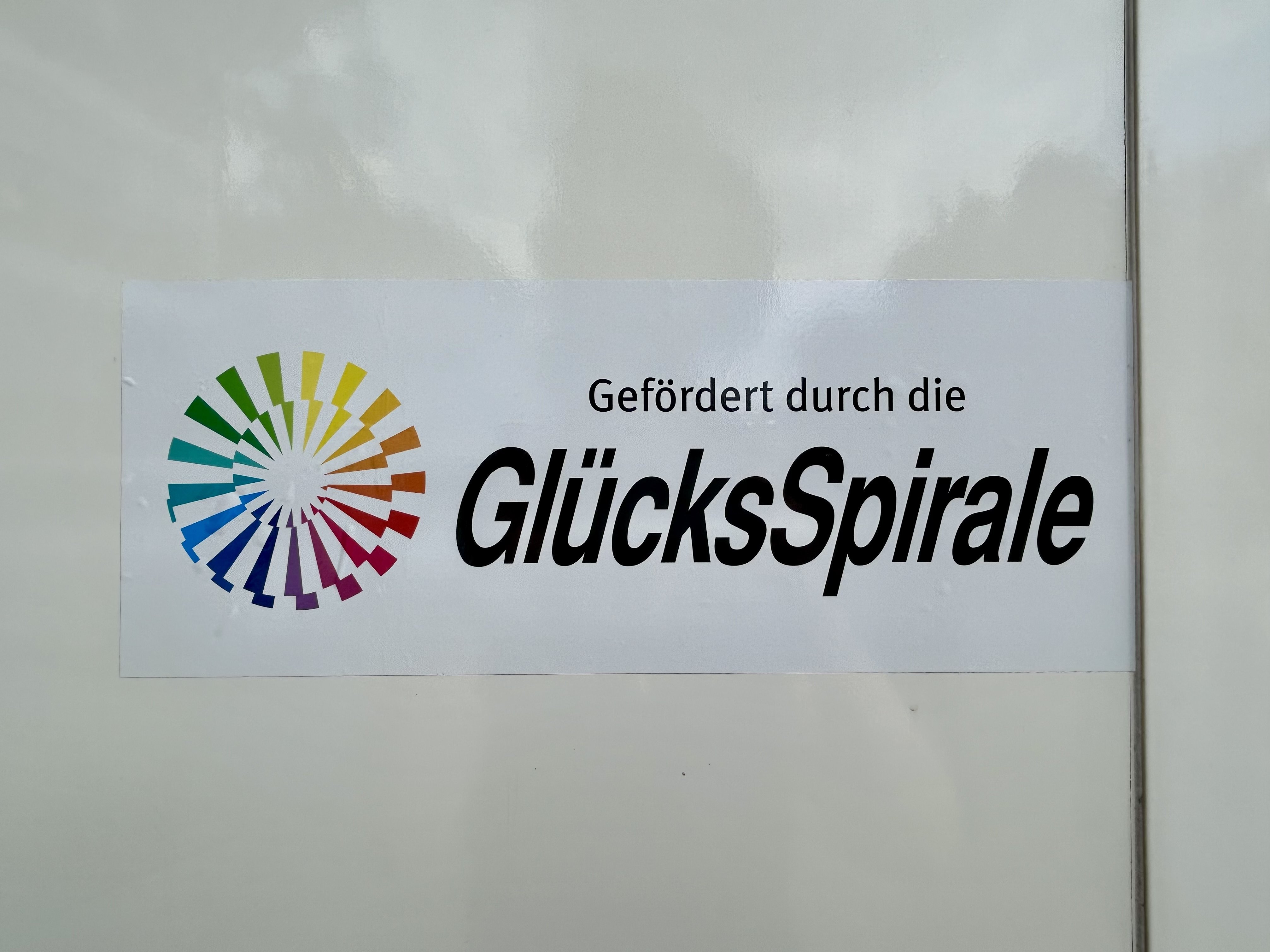 Aufkleber mit dem Schriftzug „Gefördert durch die GlücksSpirale“ auf der Seitenwand des neuen Fahrzeugs des Möbeldienstes der Diakonie im Oldenburger Land.