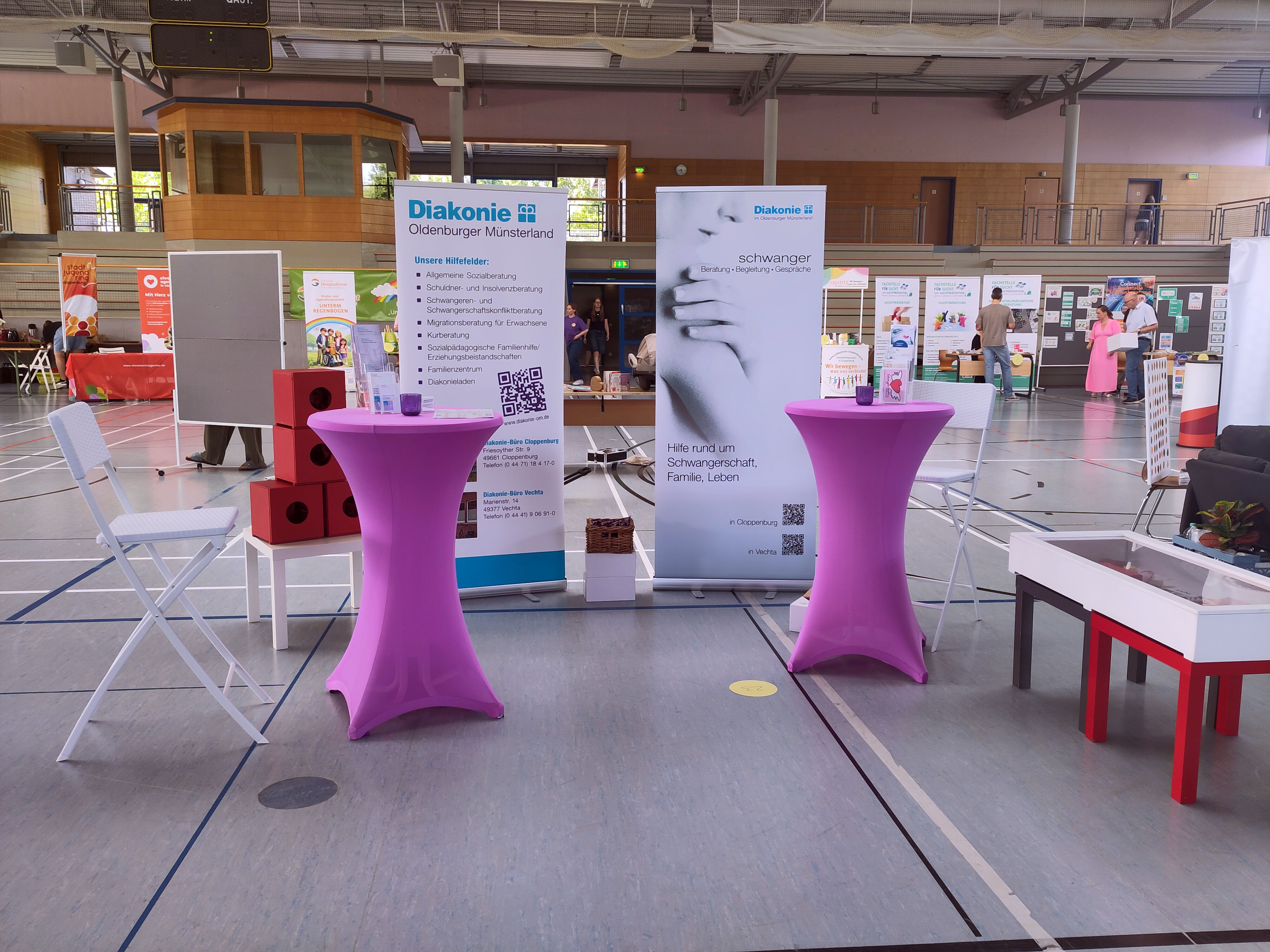 Messestand der Diakonie im Oldenburger Münsterland mit Informationsbannern, Stehtischen und interaktiven Angeboten.